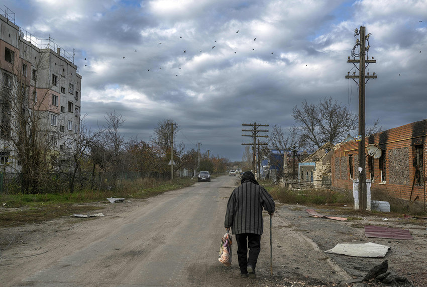 An old woman walks in the Kherson region village of Arkhanhelske on Nov. 3, 2022, which was formerly occupied by Russian forces. (Bulent Kilic/AFP via Getty Images/TNS)
