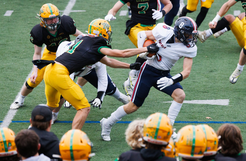 Black Hills&rsquo; Braiden Bond tries to get out from the grip of a Lynden defender as Lynden beat Black Hills 54-7 on Friday in Bellingham.