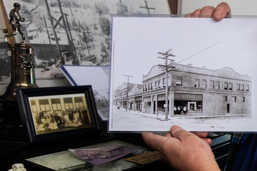 Museum President Tommy Thompson holds up a black and white photo of the Warne&rsquo;s Drug Store in downtown Winlock.
