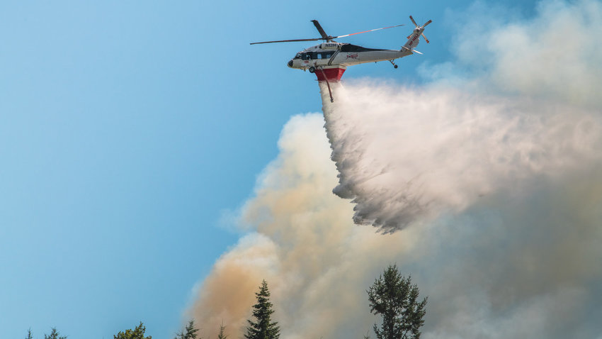 FILE PHOTO &mdash; A Department of Natural Resources helicopter flies over a forest fire in Bucoda in 2022.