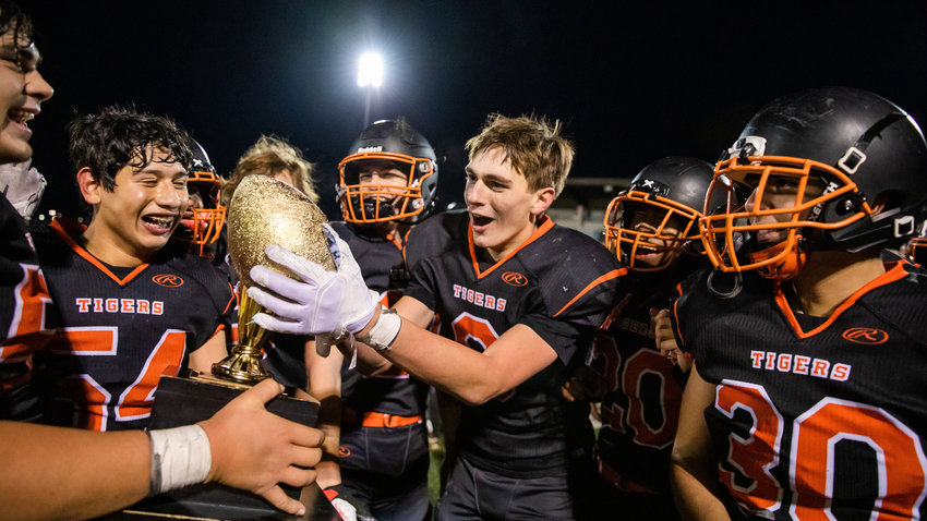 Napavine junior James Grose (8) reacts as he touches the WIAA  2B State Championship trophy Saturday night at Harry E. Lang Stadium in Lakewood after defeating Okanogan.