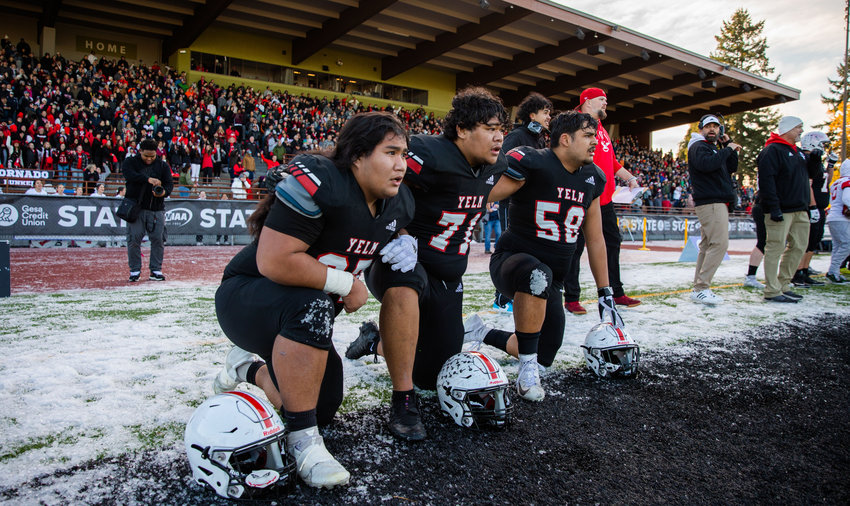 From left, Yelm linemen Kolby Henry, Ami Fakava and Kyle Kaaiwela kneel on the sidelines as they watch their teammates battle for the 3A state championship title against Eastside Catholic in Puyallup on Saturday, Dec. 3.