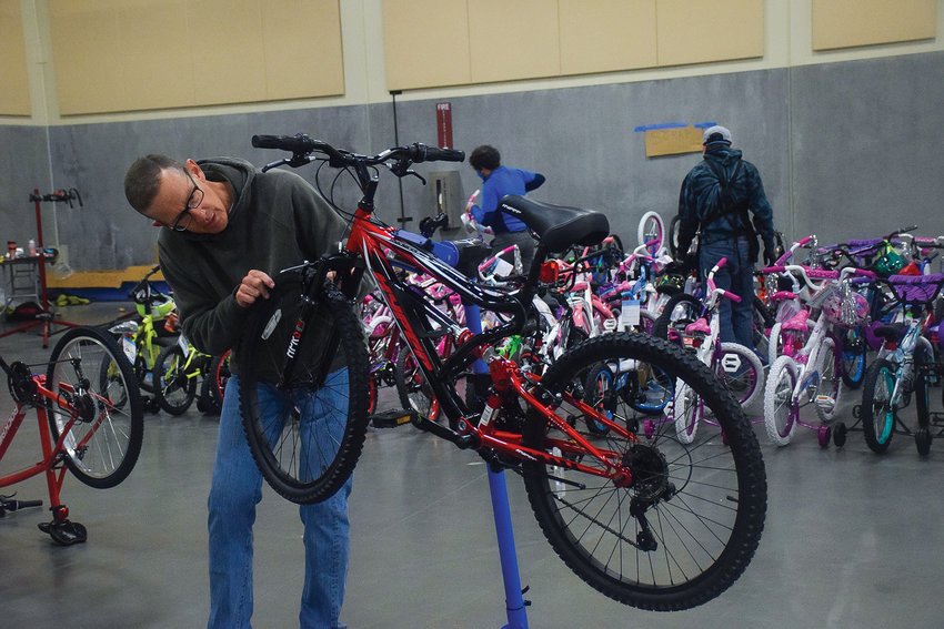 Vancouver Bicycle Club member Mike Detlef inspects one of hundreds of bikes put together as part of Waste Connections&rsquo; 12th annual Bike Build at the Clark County Fairgrounds on Dec. 10.