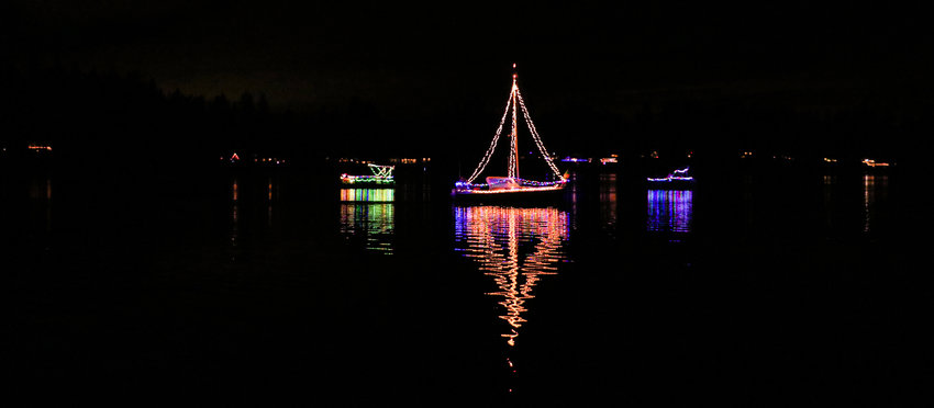 Boats are illuminated with Christmas lights on Offut Lake in Tenino Saturday night.