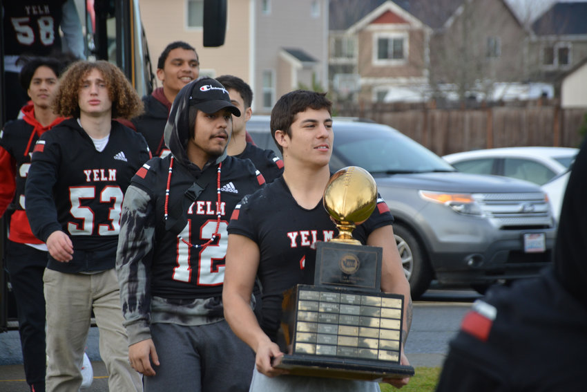 Ray Wright sports the 3A State Championship trophy as the team enters Yelm Middle School on Friday, Dec. 9.