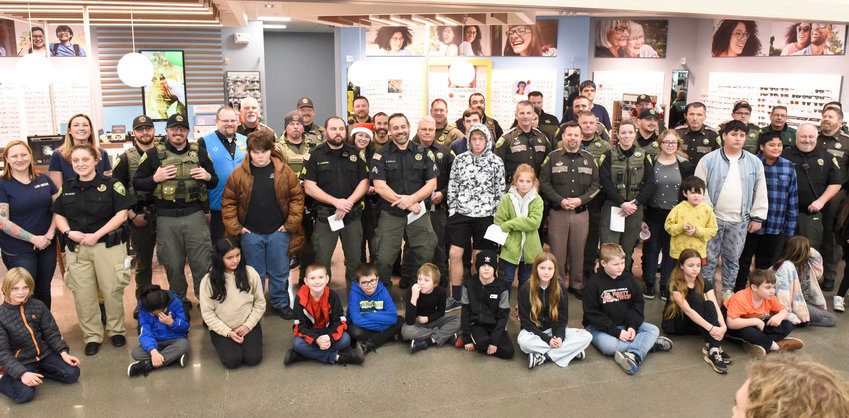Lewis County Sheriff&rsquo;s Office personnel, United Way of Lewis County staff and Chehalis Walmart staff pose for a photo with the kids participating in the 21st Annual Shop With a Cop event in Chehalis on Wednesday.