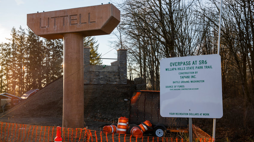 Supports for an overpass at state Route 6 read &ldquo;Littell&rdquo; along the Willapa Hills State Park Trail in December 2022 as the sun sets.