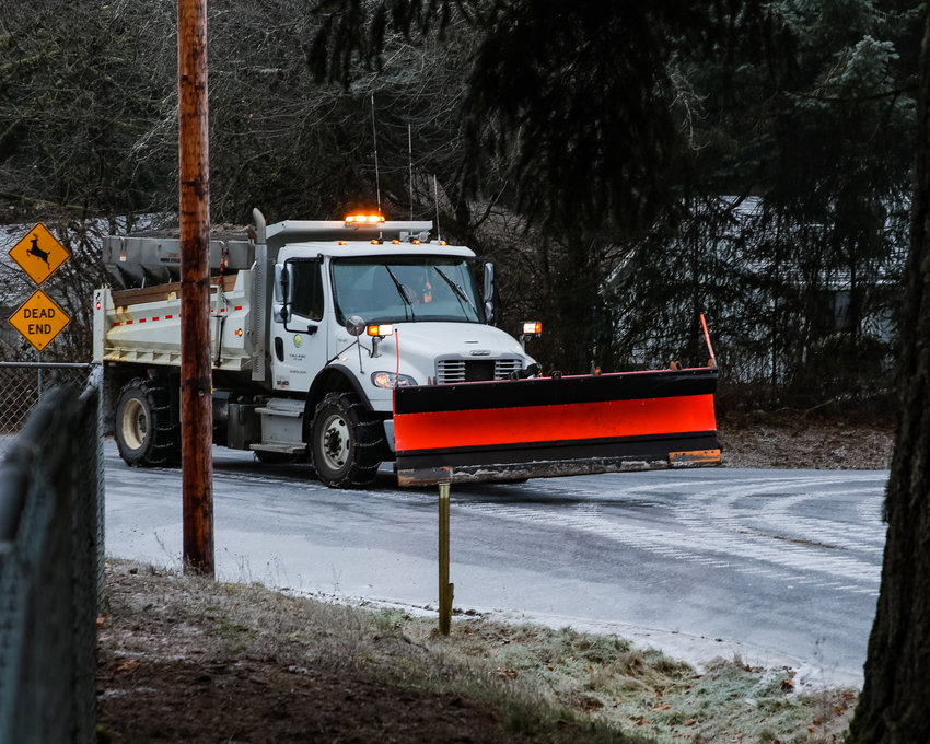 A snow plow travels on Charter Oak Road in Battle Ground on Friday, Dec. 23.&nbsp;