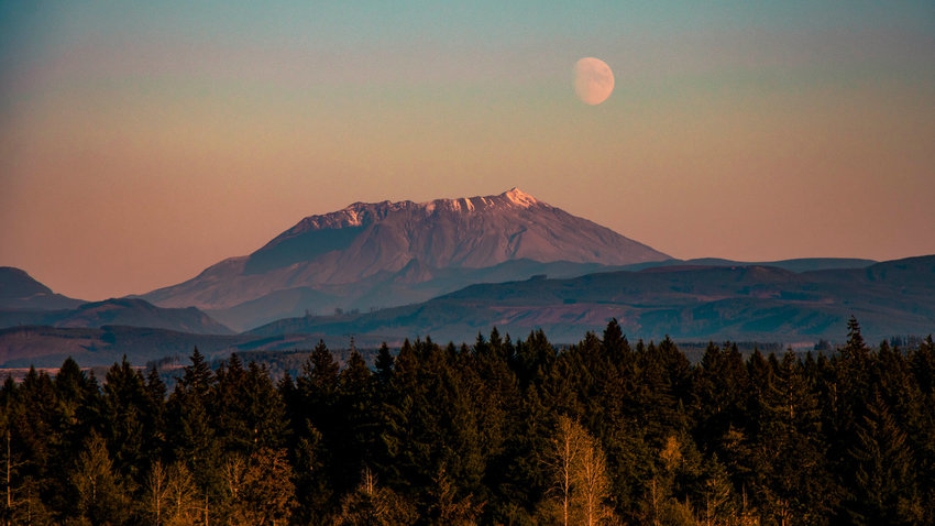 The moon rises above Mount St. Helens at sunset last March. Sediment control downriver of Mount St. Helens is among the projects funding by recently-passed federal legislation.