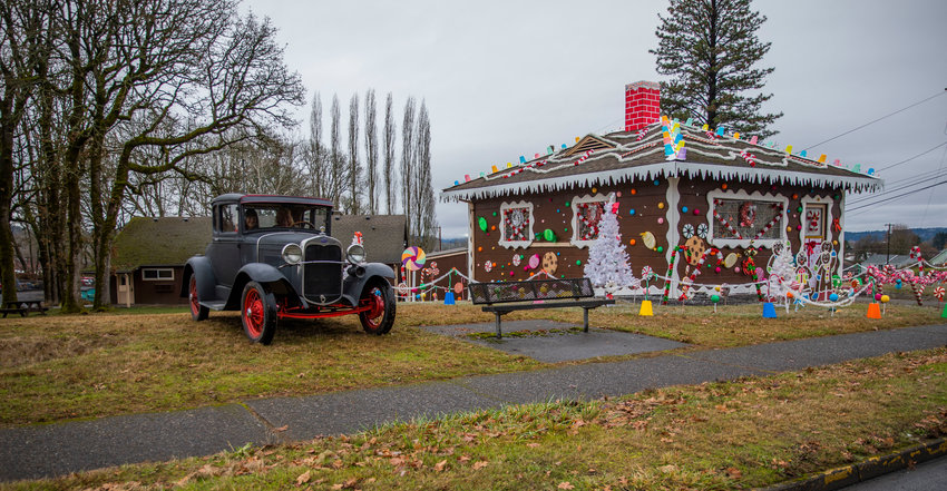 A 1930 Ford Model A visits the locally famous gingerbread house on Market Boulevard after traveling from Toledo to Chehalis on Christmas Day.