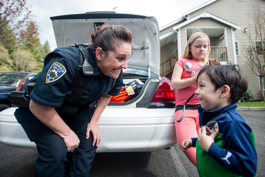 Centralia police officer Angie Krause smiles after giving Nico Ambrisio, 2, an officer's sticker as her sister, Taylor Joyce, 8, looks on in this April 2, 2014, Chronicle file photo.