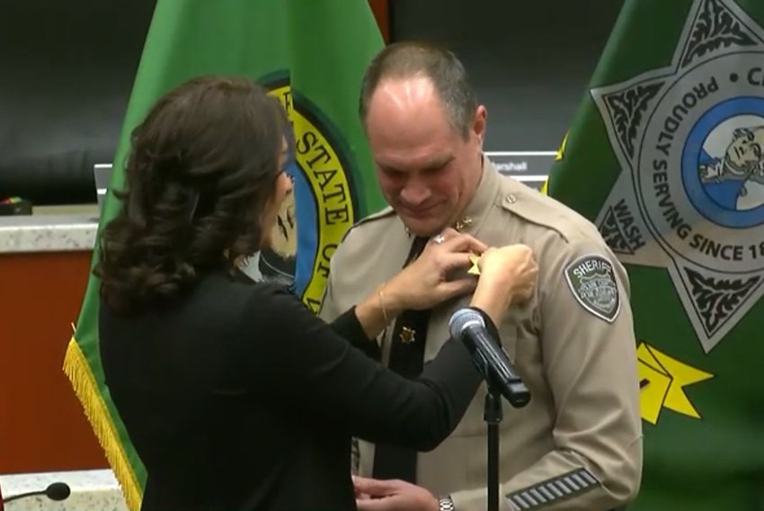 Newly-elected Clark County Sheriff John Horch, right, has his wife, Michelle, pin his badge on during a swearing in ceremony at the county public service center on Dec. 22.