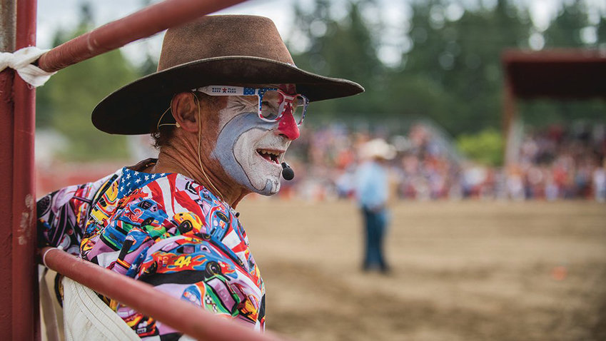 A rodeo clown smiles while watching riders in the Roy Pioneer Rodeo in September.