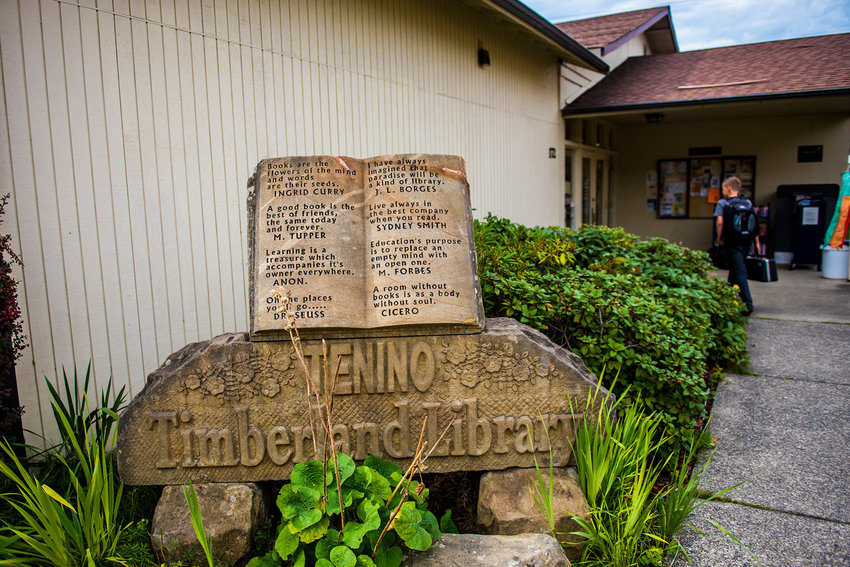 A student walks by a statue made for the Tenino Timberland Library with his backpack and instrument in this file photo.