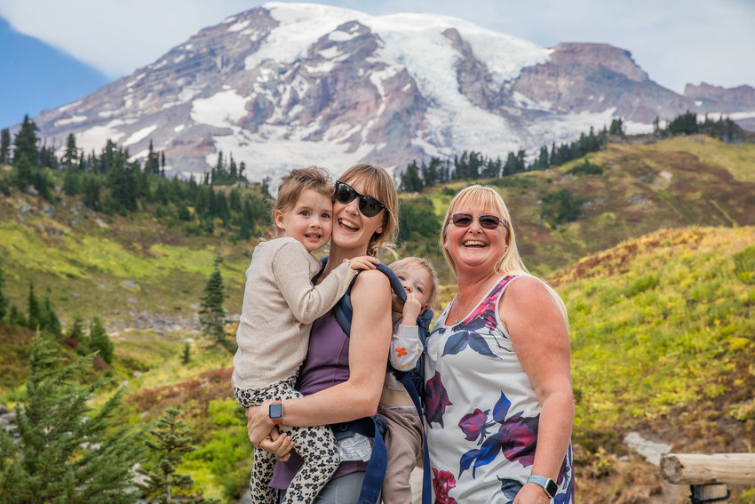 Visitors smile while posing for a photo in Paradise at Mount Rainier in 2022.