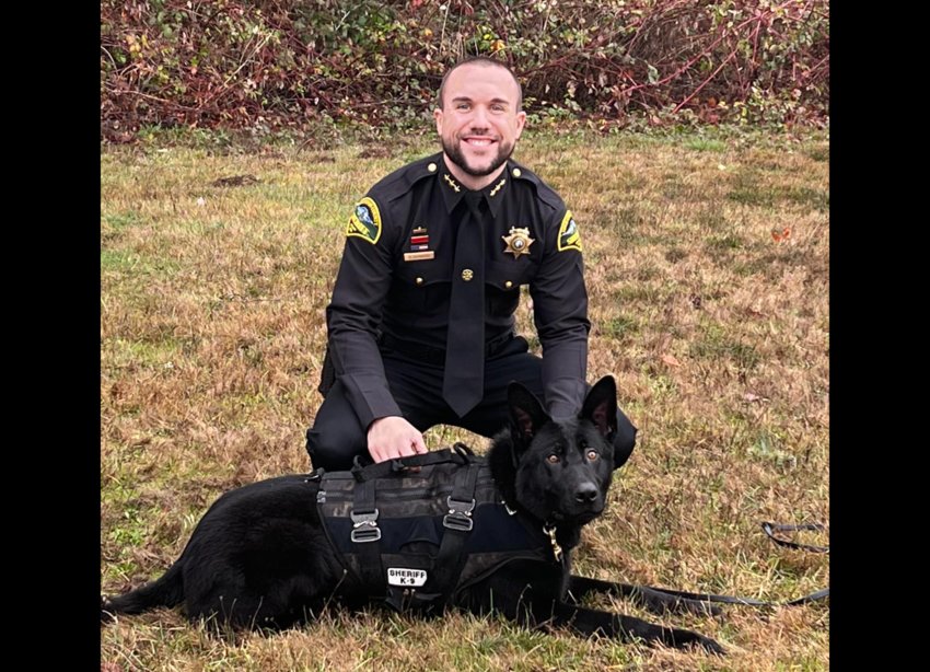 Sheriff Derek Sanders poses with a K9 in this photo provided by the Thurston County Sheriff's Office.