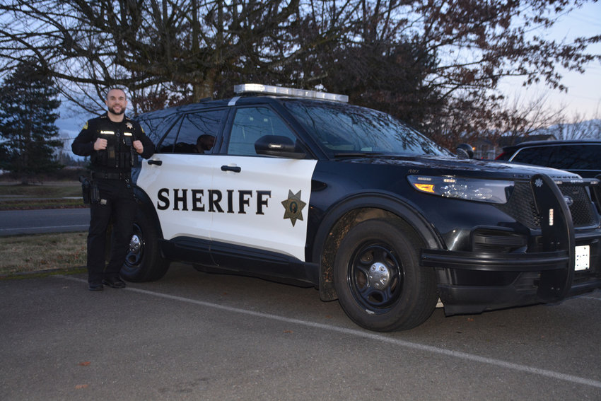 Thurston County Sheriff Derek Sanders poses for a photo in front of his vehicle.