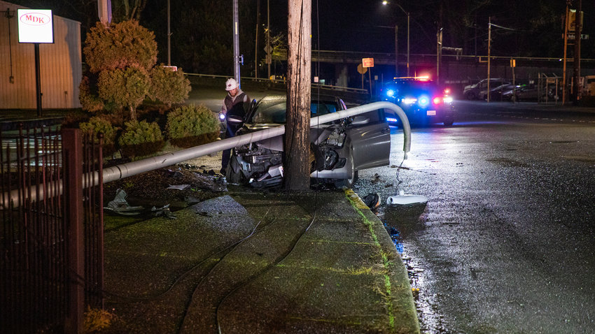 Crews use lights to illuminate a scene where a car struck a light pole along South Gold Street in Centralia Wednesday night.