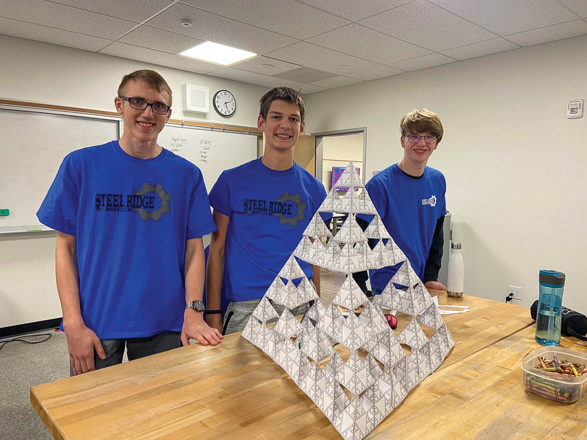 Members of the Steel Ridge Robotics team show off a successful paper structure build.