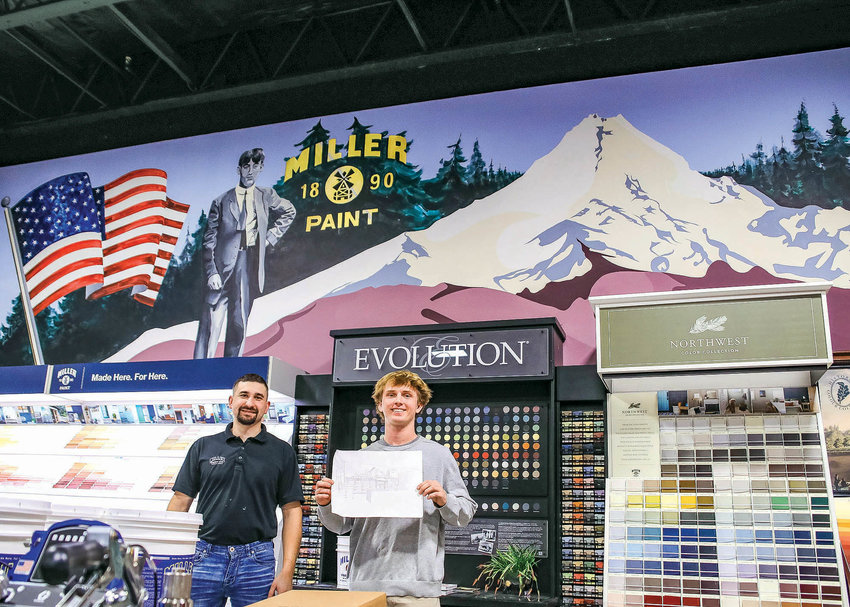 Miller Paint store manager Kyle Huffstutter, left, and artist Pace Aho, right, stand in front of Aho&rsquo;s mural done at the store as Aho holds a pre-sketch for his free-hand mural.