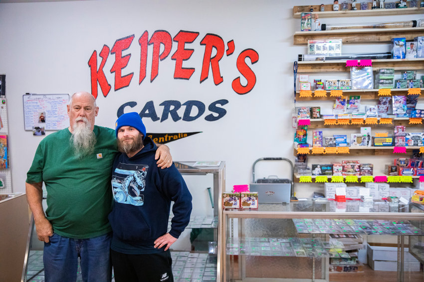 Charlie Redmon and Dan Keiper pose for a photo inside Keiper&rsquo;s Cards in downtown Centralia on Thursday.