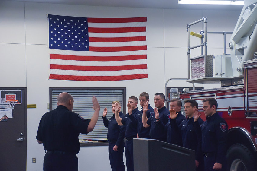 From left, Clark-Cowlitz Fire Rescue Chief John Nohr swears in firefighter/EMT Oliver Godson, firefighter/paramedic Bryan Carroll, firefighter/EMT Michael Barnes, firefighter/EMT Cutter Wicks, firefighter/EMT Austin Springer, firefighter/paramedic Joe Bailiff and firefighter/EMT Ryan Sutton during a ceremony at the district&rsquo;s Station 21 in Ridgefield on Jan. 31.