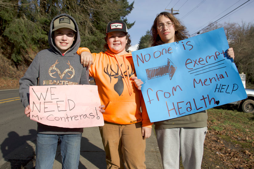FILE PHOTO &mdash;&nbsp;Winlock 6th-grader, Dylin, center, and 8th-graders Tucker and Xavier stand with their signs protesting Winlock School District staff layoffs last month.