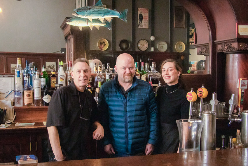 The Shire Bar &amp; Bistro's owner Joel Wall, left, stands next to one of The Shire's original employees, Chris Bruce, and bartender Lacey Heaton. The downtown Chehalis Bar celebrated 20 years in business this past week.