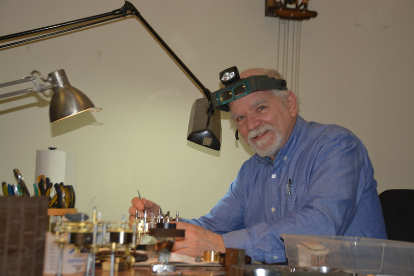 Lance Howard poses for a photo while he works on a clock at Mount Rainier Clock Repair in Yelm.