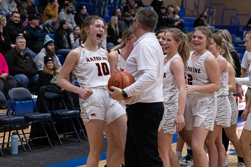 Napavine's Keira O'Neill (10) celebrates with her coach, Shane Schutz, and the rest of the team after a 53-52 win over Rainier in the 2B District 4 semifinals at Kelso Feb. 14.