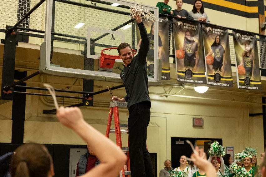 Tumwater girls basketball coach Nathan Buchheit celebrates after cutting down the nets and a 2A District 4 title win over W.F. West Feb. 17 at Hudson's Bay.