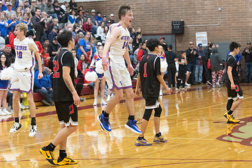 Willapa Valley's Derek Fluke (14) and Riley Pearson (10) celebrate at the final buzzer as Oakville's Ashton Boyd, Eddie Klatush, and Haezen Charles-Cayenne walk off the court after the Vikings' 62-54 win over the Acorns in the 1B District 4 title game at Montesano on Feb. 18.