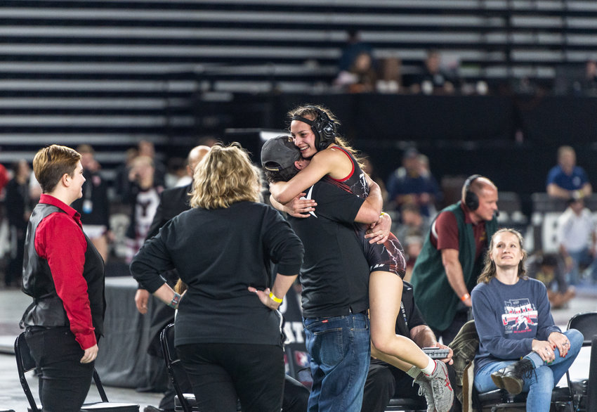Yelm&rsquo;s Madisyn Erickson, 120 pounds, jumps into her coach's arms after winning the championship at Mat Classic XXXIV on Saturday, Feb. 18, at the Tacoma Dome.