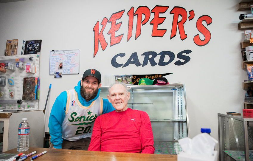 Dan Keiper, owner of Keiper&rsquo;s Cards, smiles for a photo with former professional basketball player and coach George Karl on Friday in downtown Centralia.
