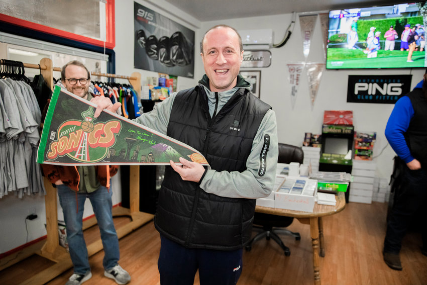 Ryan Guenther holds up a Seattle Sonics banner he has had for over 20 years, after it was autographed by George Karl last February at Keiper&rsquo;s Cards in Centralia.