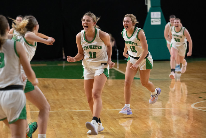Kylie Waltermeyer (11), Rhylee Beebe (12), and the Tumwater girls basketball team celebrates its 36-29 win over Enumclaw in the 2A state tournament Round of 12, March 1 in Yakima.