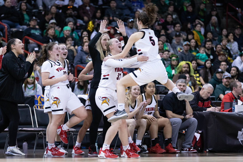 Mossyrock guard Payton Torrey (5) leaps into the arms of Hailey Brooks after defeating Inchelium in the 1B state semifinals at Spokane Arena March 3.