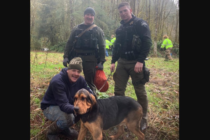 Cowlitz County Deputies James Doyle and Landen Jones pose with Nathan Mueller and his dog after being saved.
