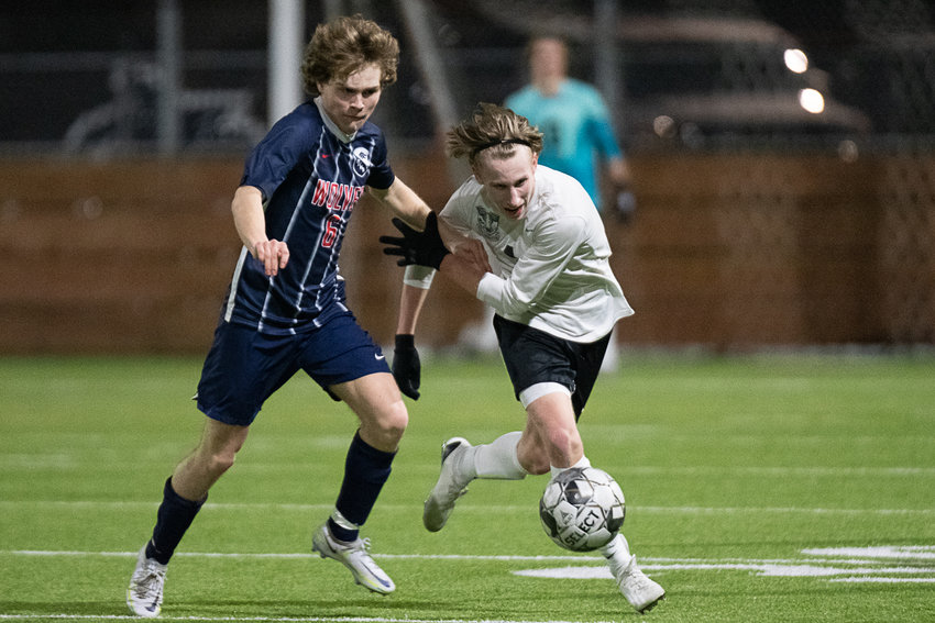 Black Hills' Camden Flahaut and Tumwater's Austin O'Connor jockey for the ball during the second half of the T-Birds' 1-0 win over the Wolves on March 16.
