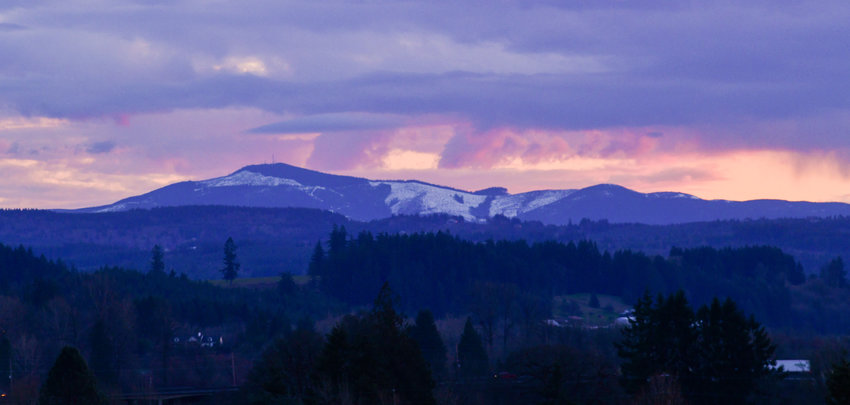 The sun sets over the snowy Willapa Hills.
