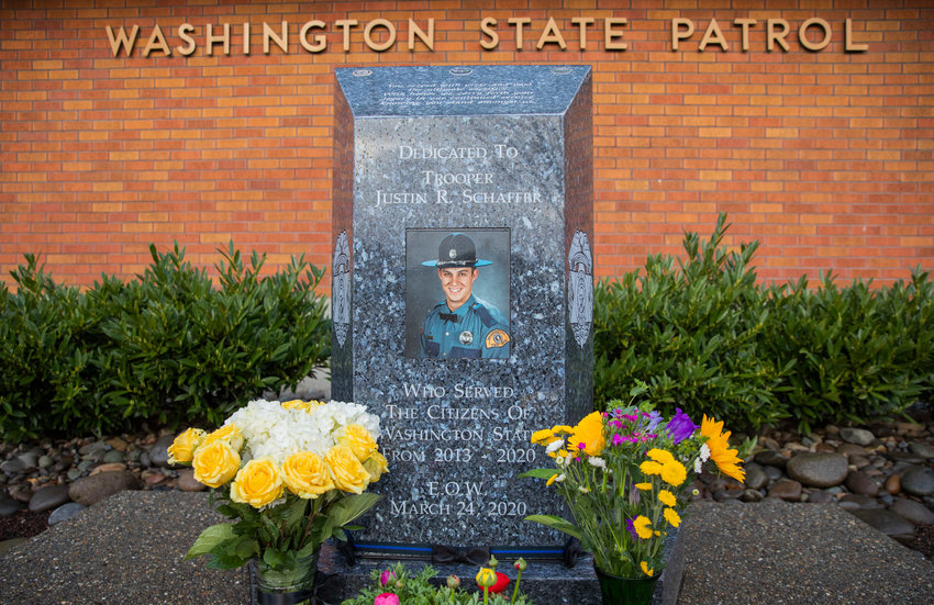 Flowers are arranged around a memorial for Trooper Justin Schaffer at the Chehalis Washington State Patrol office in 2023.
