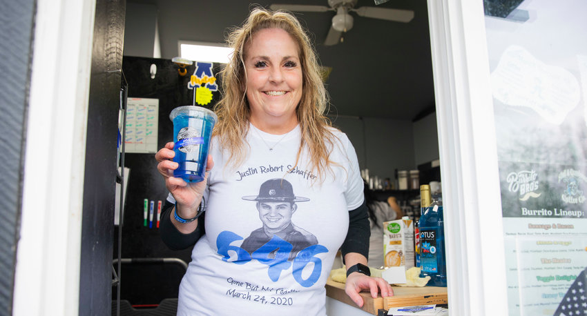 Angie Krause, formerly known as Angie Humphrey, smiles and holds up a &ldquo;Trooper&rdquo; drink available at Skull and Crossbones Coffee Co. in honor of Justin Schaffer Friday morning in Adna. On Friday, a portion of each sale went toward the Justin Schaffer Scholarship Fund in Adna. Schaffer died three years ago after he was struck by a fleeing vehicle while attempting to set spike strips. Skull &amp; Crossbones Coffee Co. is located at 109 Bunker Creek Road across from Adna Grocery. The coffee stand is open from 6 a.m. to 3:30 p.m. on weekdays and from 7 a.m. to 3 p.m. on weekends.