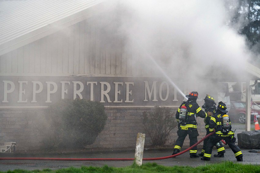 Firefighters blast water into a roof vent on the west side of the Peppertree West Motor Inn as they put out hot spots across the motel on the 1200 block of Alder Street in Centralia on Thursday, April 6. The main portion of the motel was completely evacuated and no life-threatening injuries were reported.