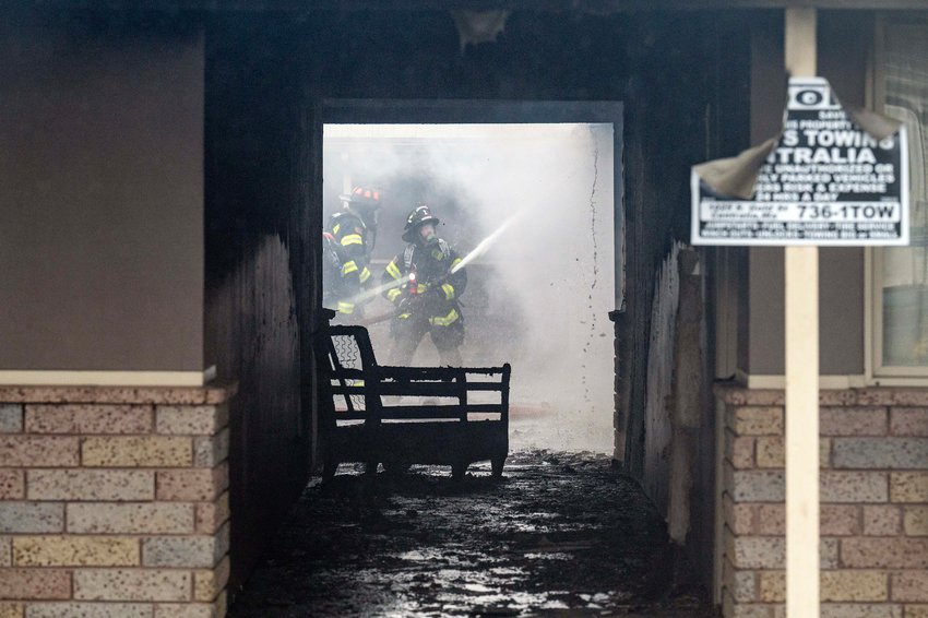 Firefighters hose down the underside of the roof of the west side of the Peppertree West Motor Inn on Thursday, April 6, 2023, in Centralia.