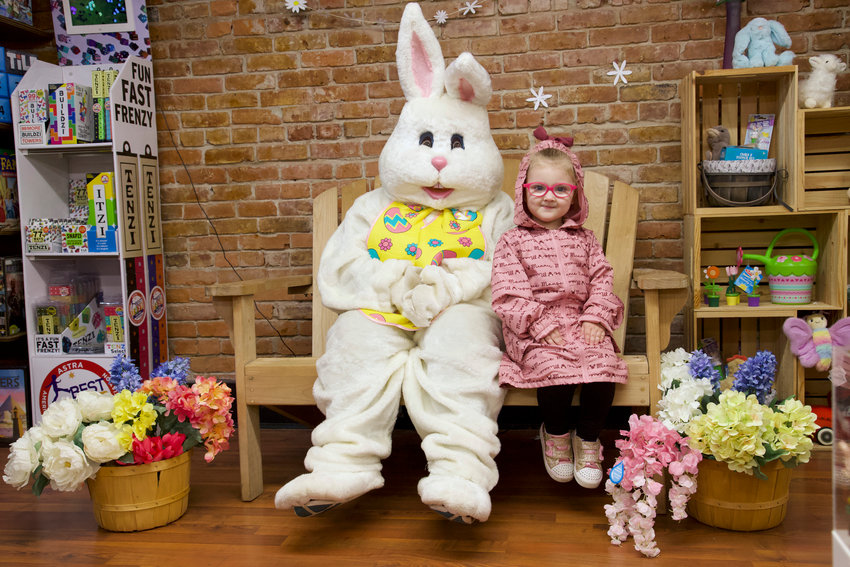 Lucy, 3, sits beside the Easter Bunny at Let&rsquo;s Play Something toy store in downtown Centralia on Saturday.