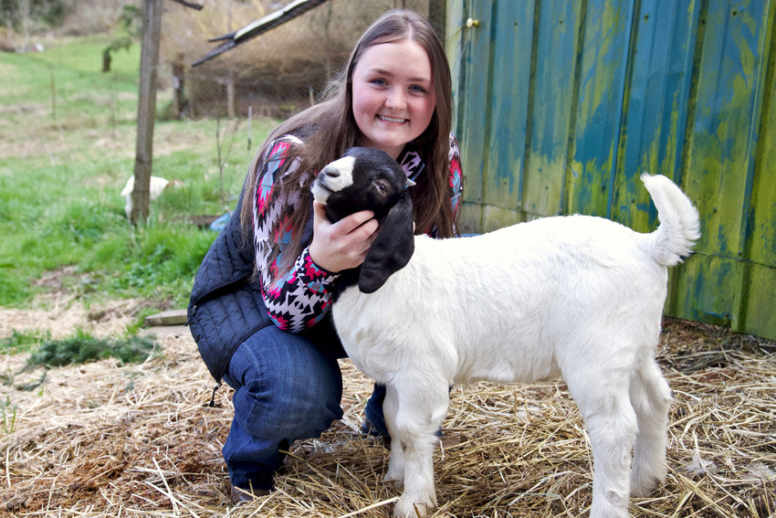 Centralia High School senior Gracee Cline poses for a photo with one of her Boer goats at Incline Farms in Centralia on Friday.