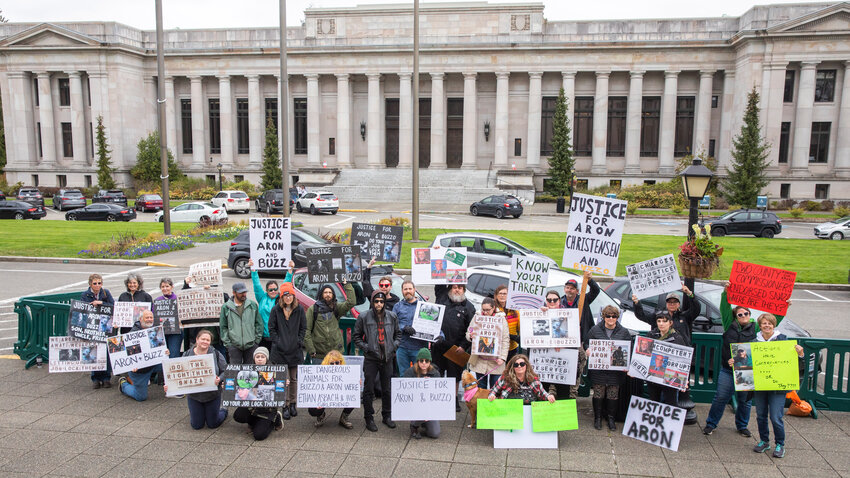 Visitors gather from across the Pacific Northwest to hold signs in protest while demanding answers in the deaths of Aron Christensen and his dog Buzzo. The protest was held outside the Washington state Capitol Building in Olympia on Sunday, April 23.