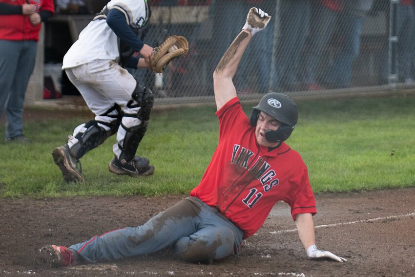 A mud-spattered Tim Bowes slides into home to score Mossyrock's second run its 3-0 win over Naselle on April 24.