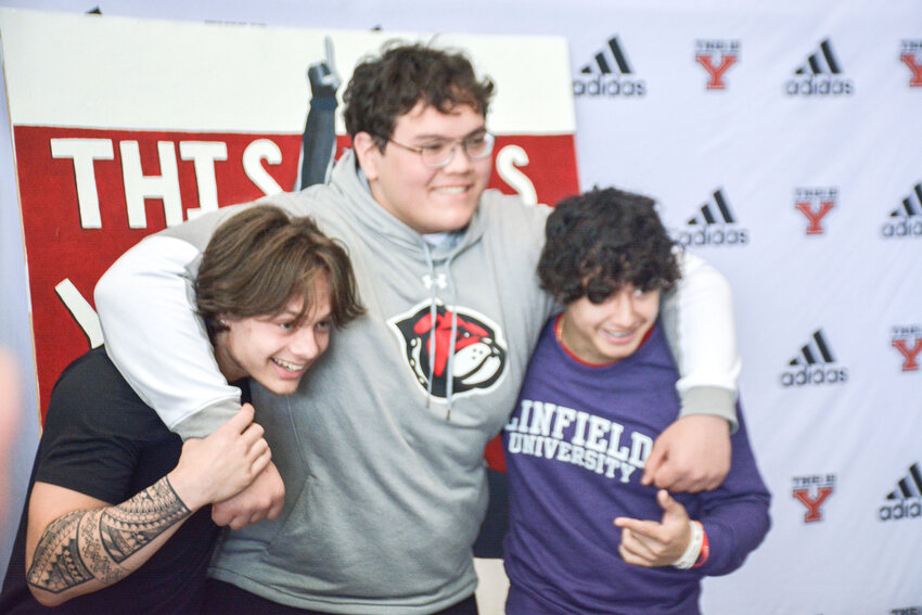 Yelm football athletes Kyler Ronquillo, William Snodgrass and Pavaan Bankston pose for a photo on Friday, April 21, after they participated in a signing ceremony at Yelm High School.