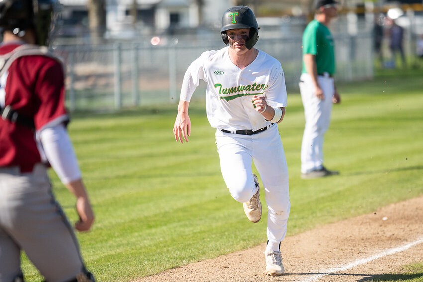 Derek Thompson comes home to score Tumwater's first run during the T-Birds' 8-3 win over W.F. West on April 28,